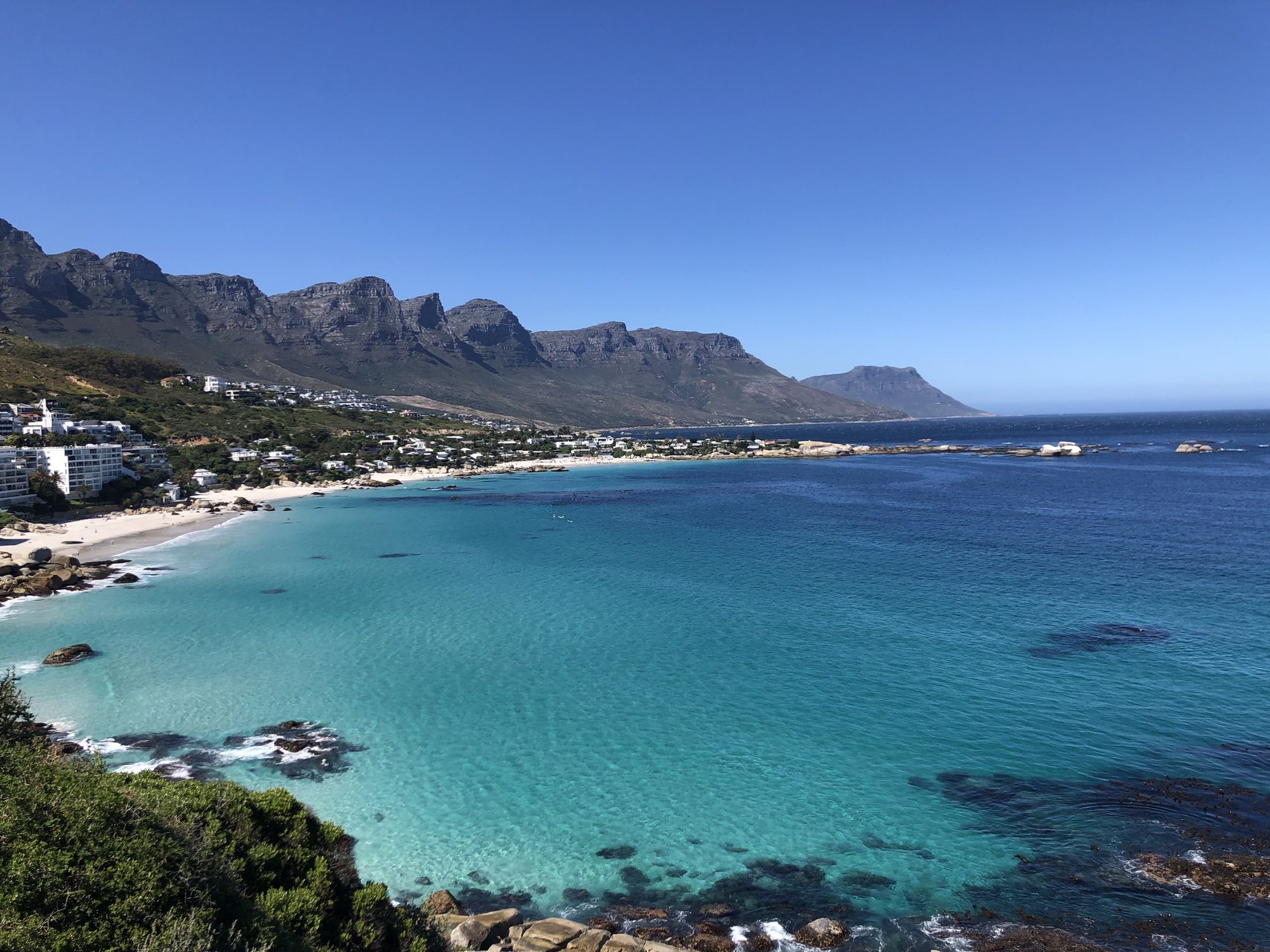 The Twelve Apostles mountain range rising above the Camps Bay coastline in Cape Town, South Africa