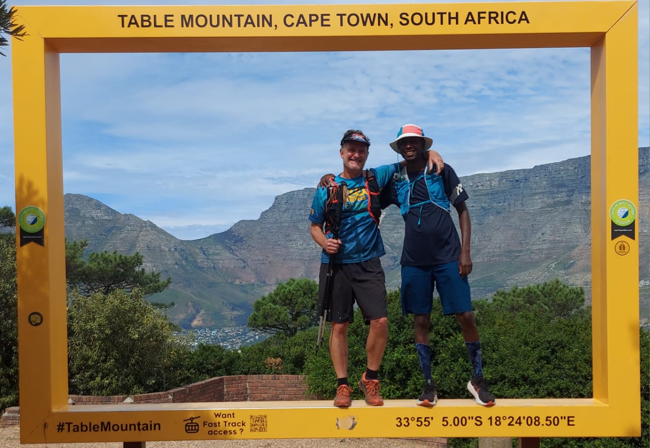 Two Cape Trail Tours guides standing in the Table Mountain, Cape Town, South Africa photo frame with the mountain behind them